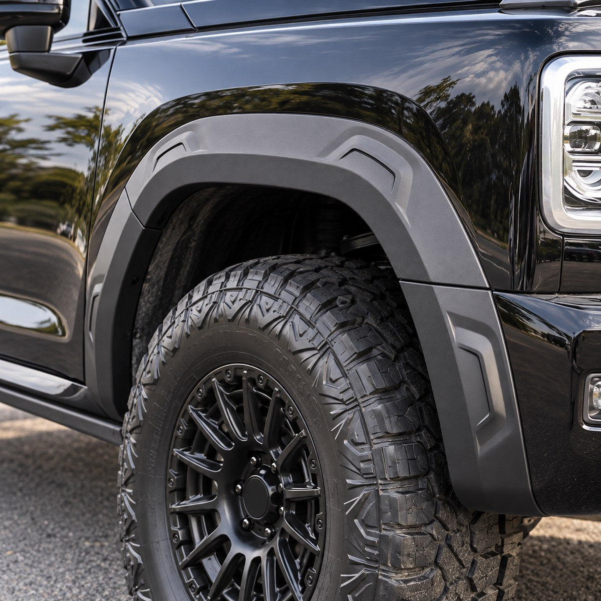 Close-up of the charcoal front wheel arch trim installed on a black GWM Haval H9 2024+