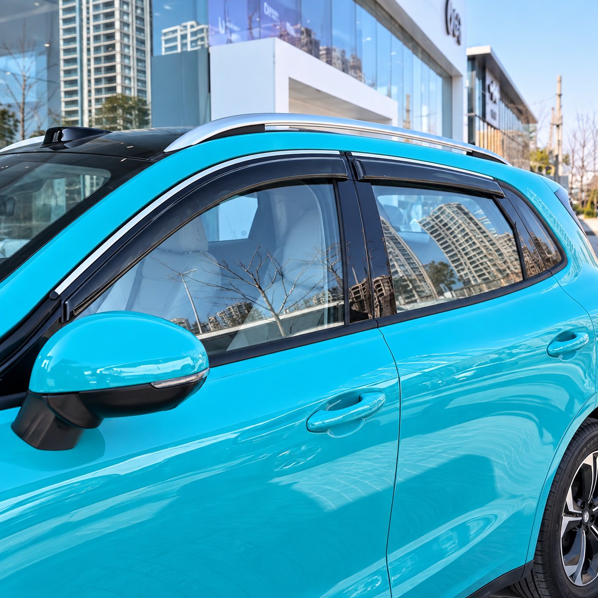 Black side window visors installed on a turquoise GWM ORA 5 2026 viewed from the front right side